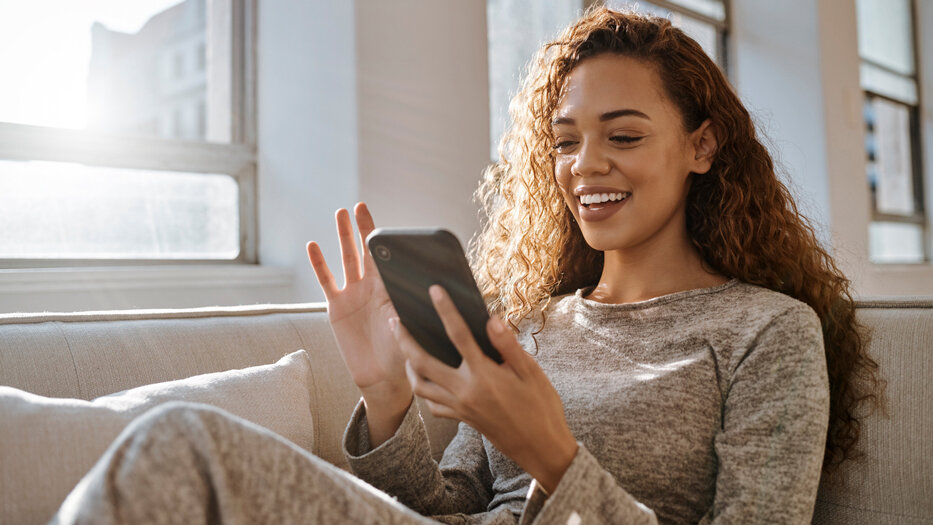 Grey-haired woman shows her smartphone with opened AusweisApp in the camera